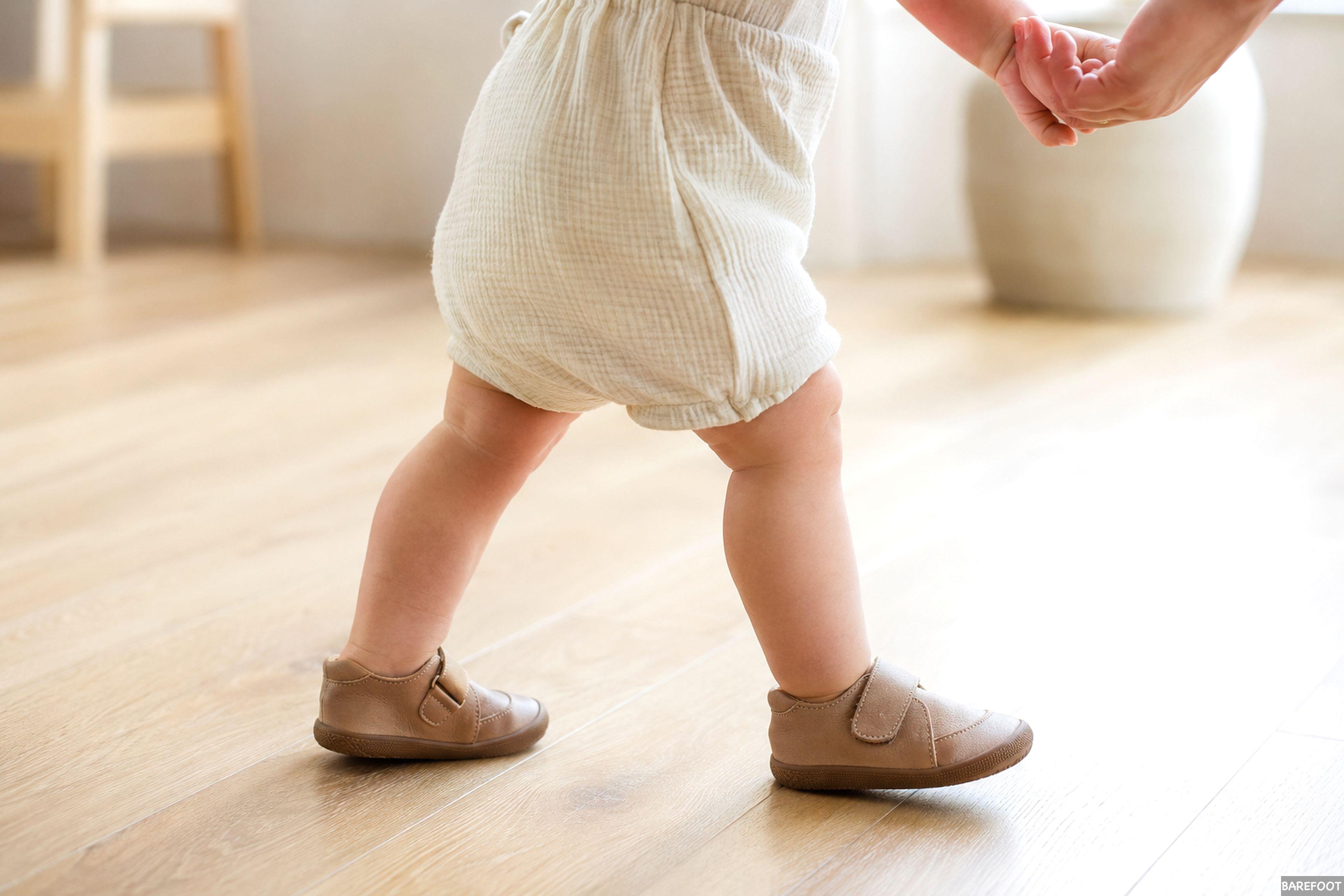 Bebé dando sus primeros pasos con zapatos respetuosos