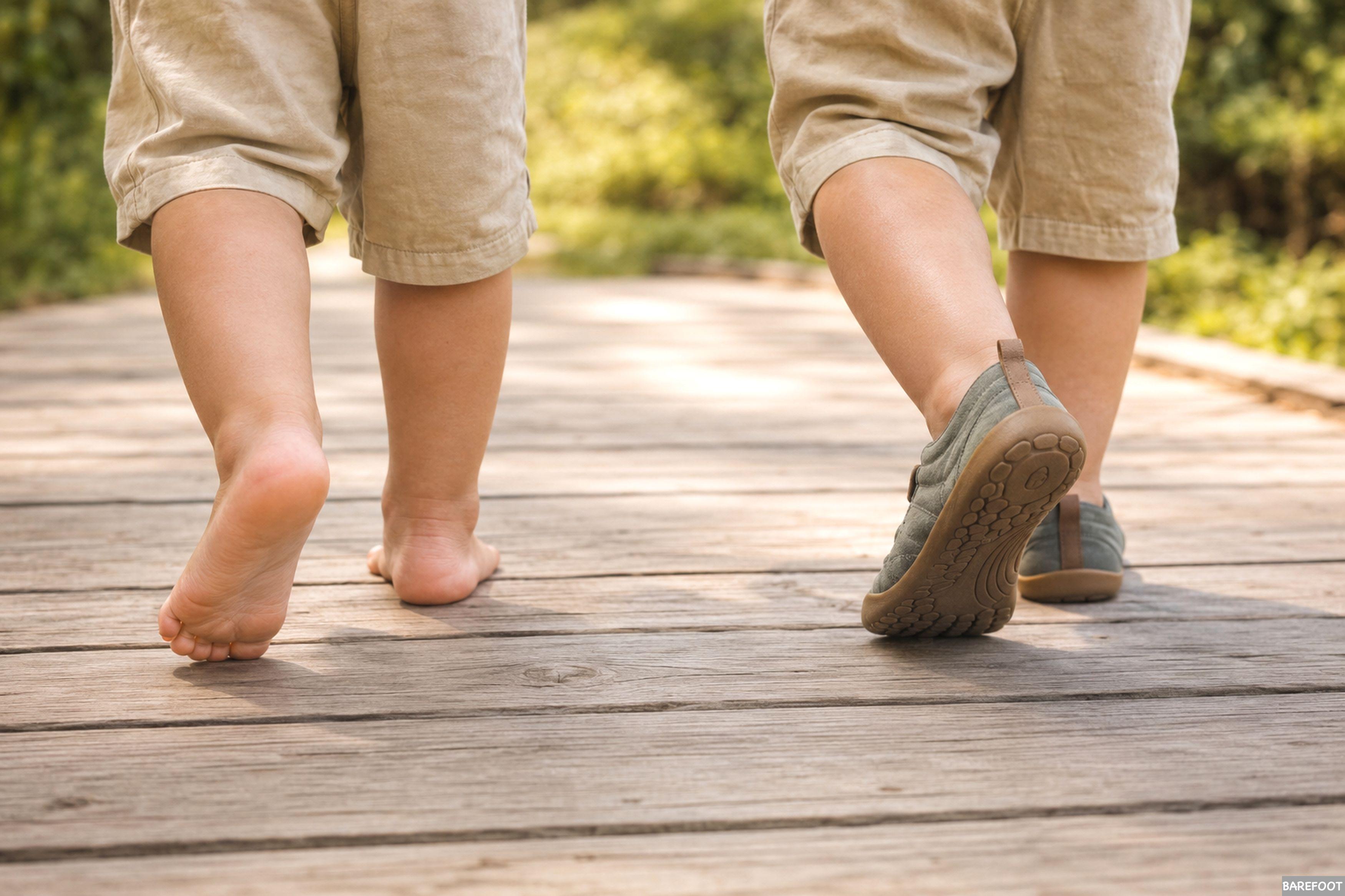 Niño caminando descalzo junto a otro niño con calzado barefoot